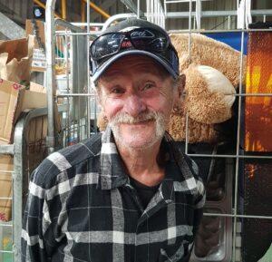 Smiling older man in cap at market stall